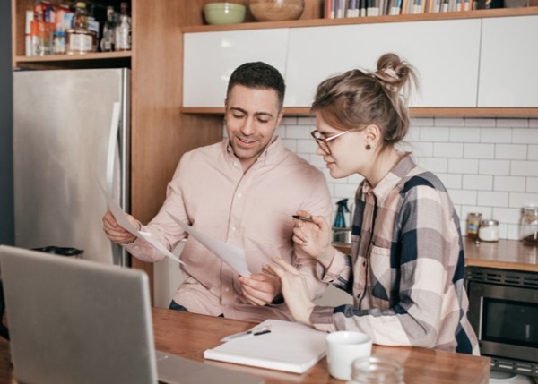 Casal jovem a planear o orçamento familiar e a comparar spreads bancários